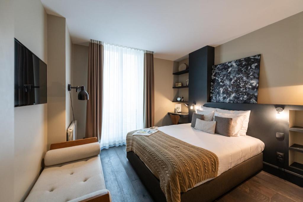 a hotel room with a large bed and a large window at 1er Etage Marais in Paris