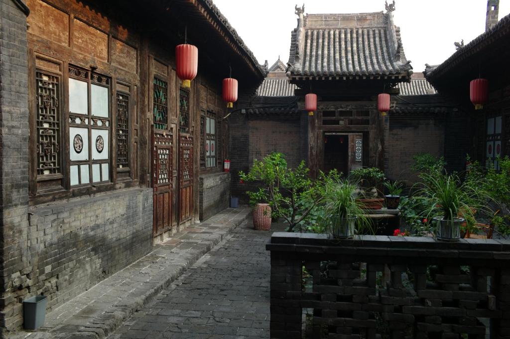 an alley in an old building with red lanterns at Pingyao Yide Hotel in Pingyao