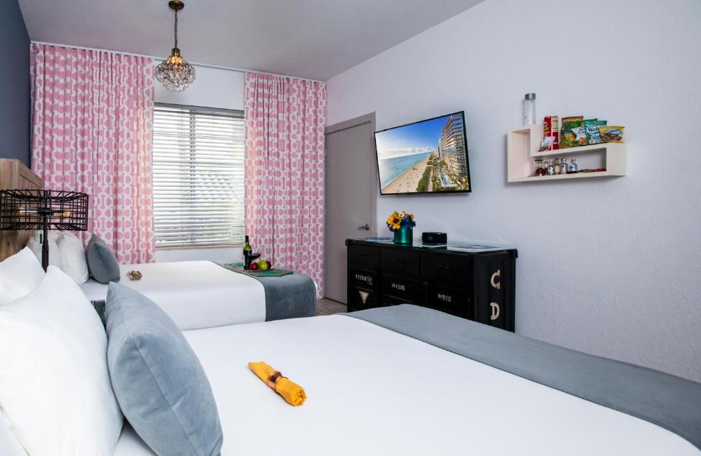 a bedroom with two beds and a window at Whitelaw Hotel in Miami Beach