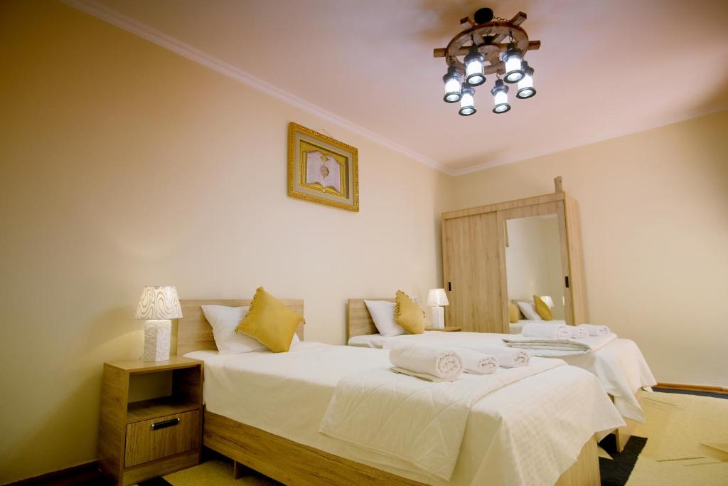 1 dormitorio con 2 camas y lámpara de araña en Khalima, en Bukhara