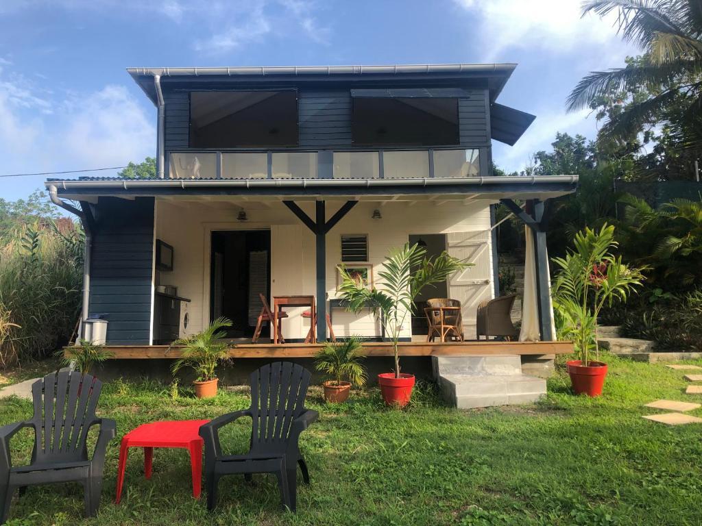 ein blaues Haus mit Stühlen und einem Tisch in der Unterkunft Agréable appartement à 2 pas des plages in Le Gosier