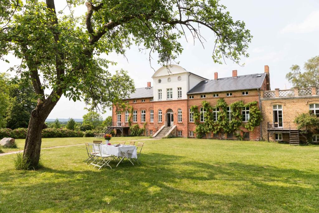 a picnic table on the lawn of a large house at Gut Pohnstorf in Alt Sührkow