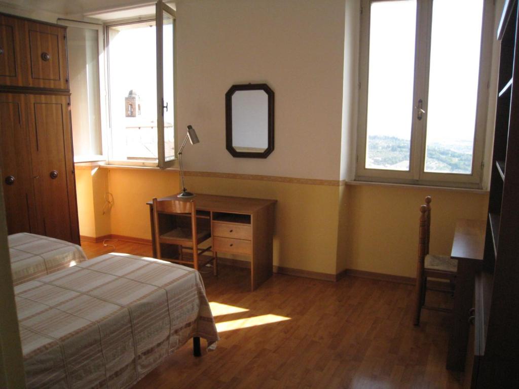 1 dormitorio con cama y escritorio con espejo en Casa Mariotti, en Perugia