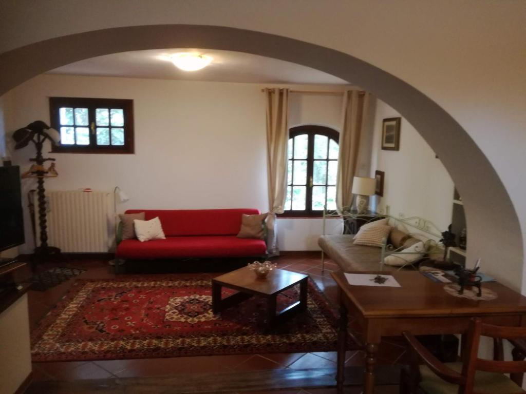 ein Wohnzimmer mit einem roten Sofa und einem Tisch in der Unterkunft TUSCANY EASY HOLIDAYS in Capannoli