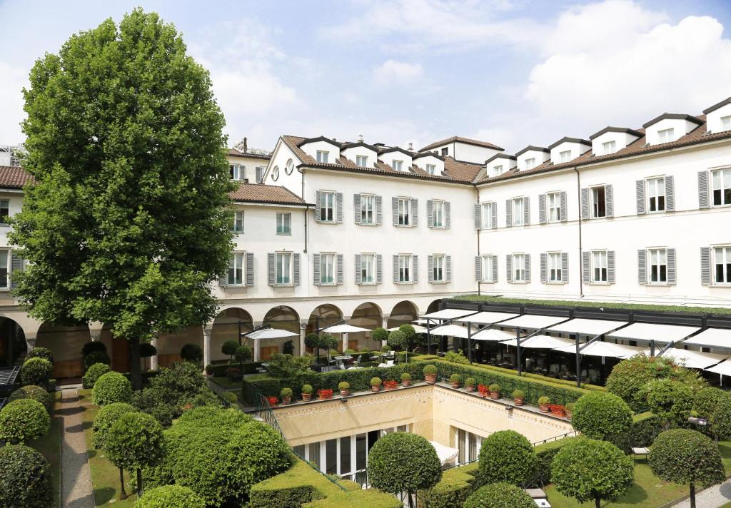 un gran edificio blanco con un jardín delante de él en Four Seasons Hotel Milano en Milán