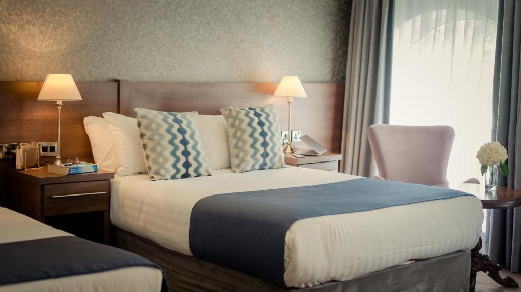 um quarto de hotel com uma cama grande e uma janela em Woodford Dolmen Hotel Carlow em Carlow