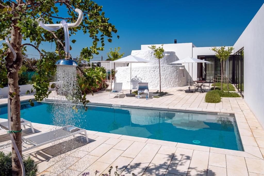 een zwembad voor een wit huis bij Villa ELGAR in Ostuni