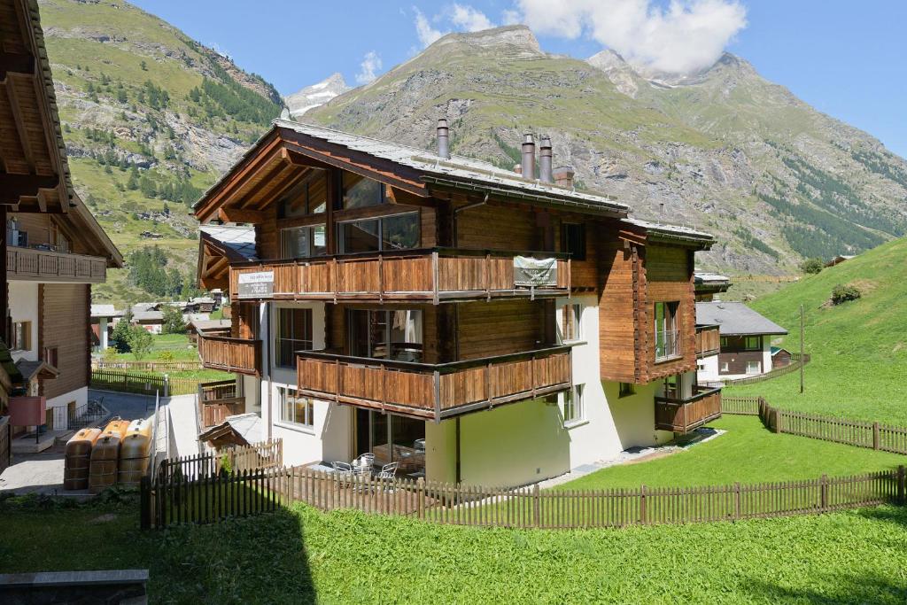 ツェルマットにあるカーサ デッラ ヴィータの山を背景にした木造家屋