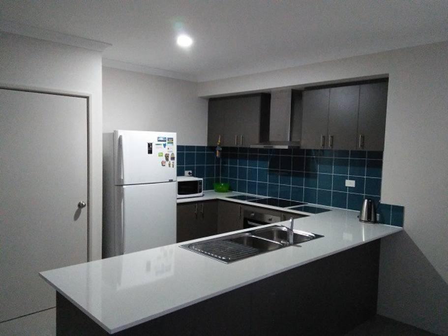 a kitchen with a white refrigerator and a sink at Near Train Station in Perth