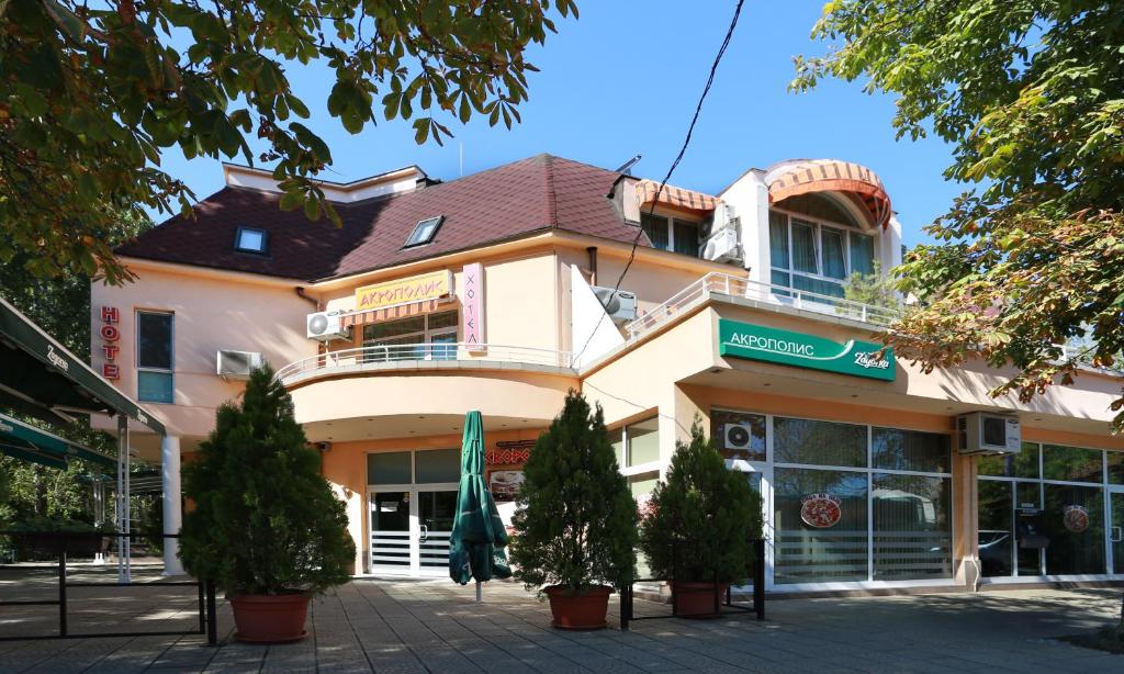 a large building with trees in front of it at Acropolis Hotel in Pazardzhik