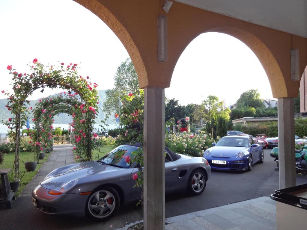 zwei Autos auf einem Parkplatz mit Rosen geparkt in der Unterkunft Hotel Schweizerhof in Weggis