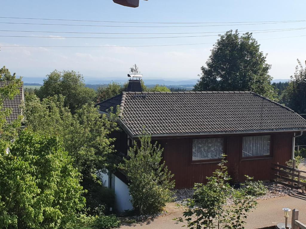 a house with a roof with trees in front of it at Ferienhaus Waidmanns-Heil in Höchenschwand