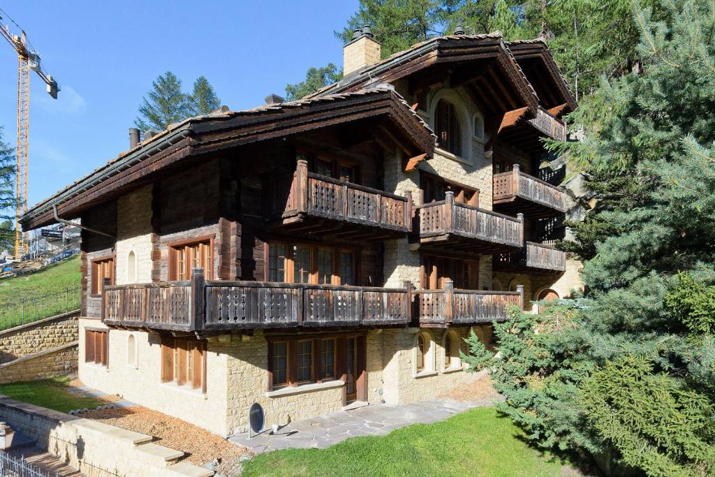 a large house with balconies on the side of it at Chalet Kisseye with heated Pool and Matterhorn views in Zermatt