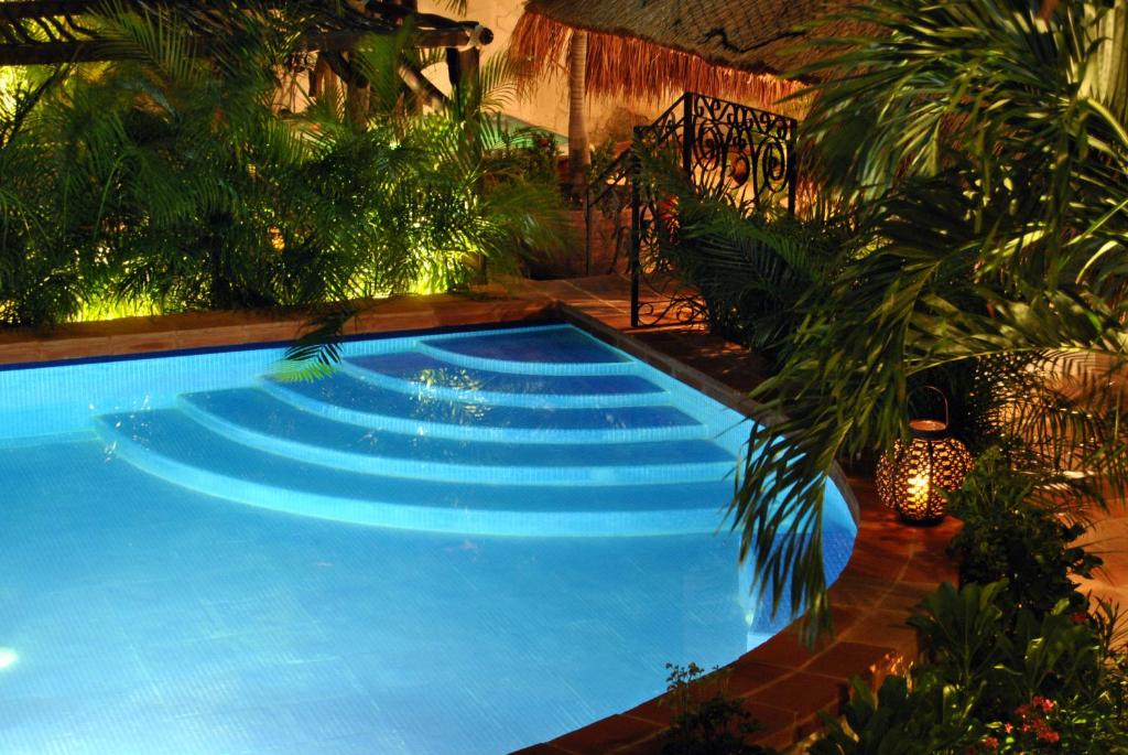 una gran piscina azul en un jardín en La Pasion Colonial Hotel Boutique By Bunik, en Playa del Carmen