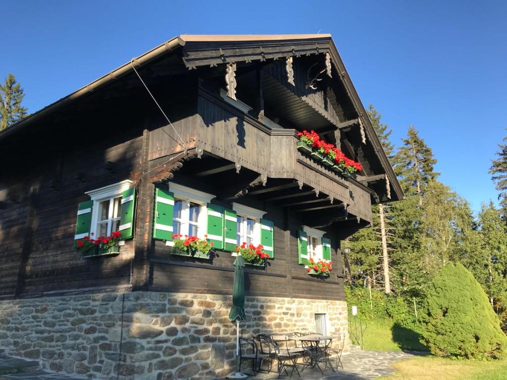 ein Haus mit einem Balkon mit Blumen darauf in der Unterkunft Ferienhäuser Gerlitze in Kanzelhöhe