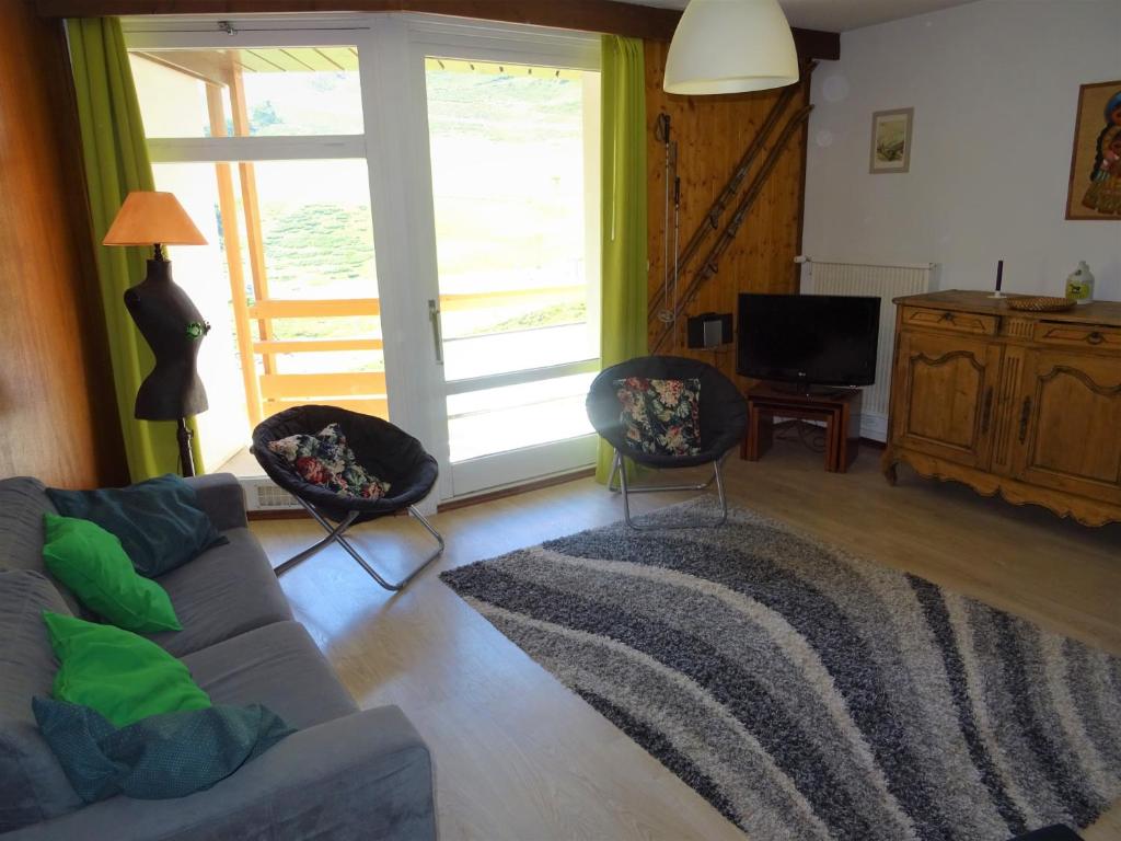 een woonkamer met een bank en 2 stoelen bij T2 confort,Vue d'Exception,calme,prés des pistes in La Mongie