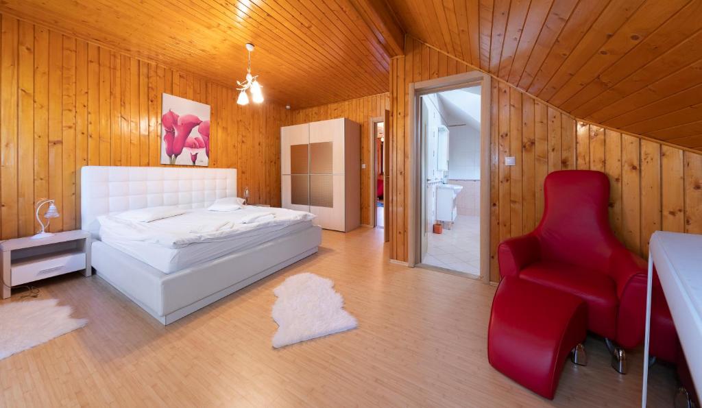 ブシュテニにあるVilla Moonのベッドルーム(白いベッド1台、赤い椅子付)