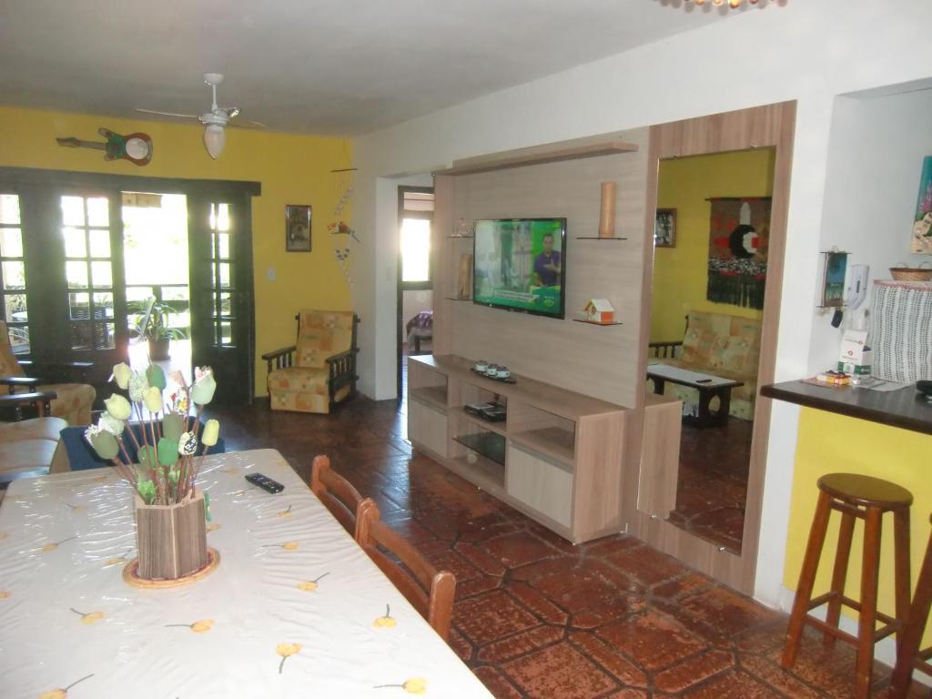a living room with a table with flowers on it at apartamento a 20 metros do mar bombinhas in Bombinhas
