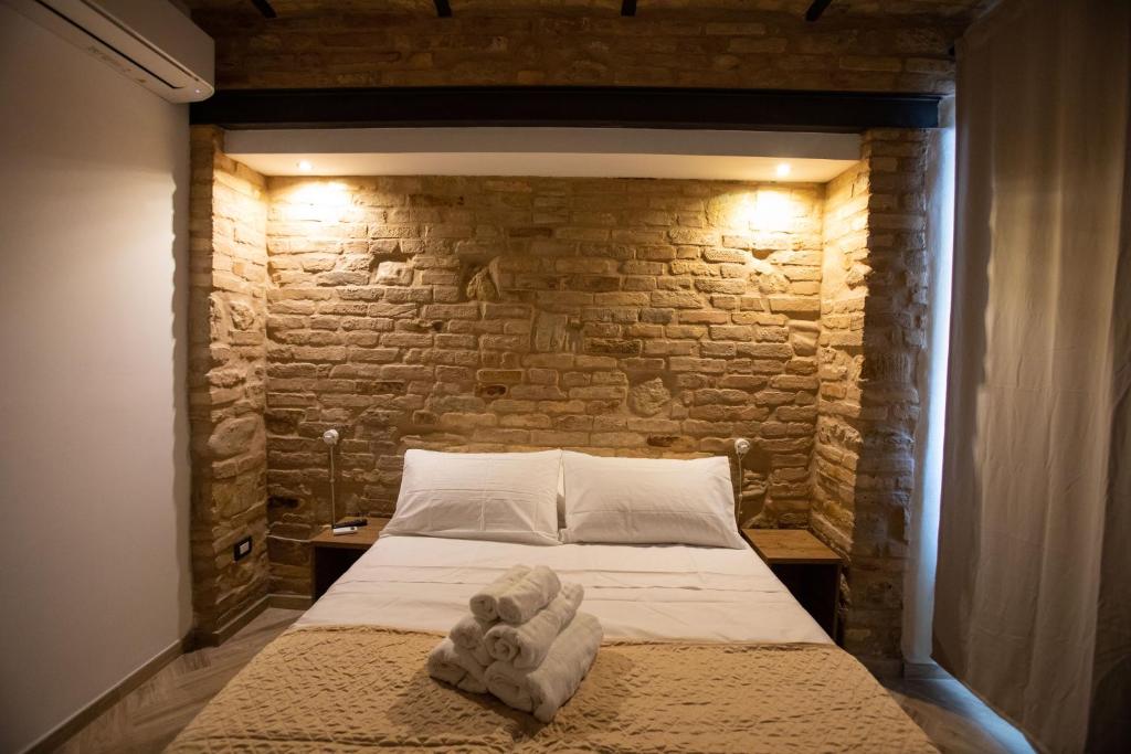 um quarto com uma cama com uma parede de tijolos em AL 54 Accommodation em San Benedetto del Tronto