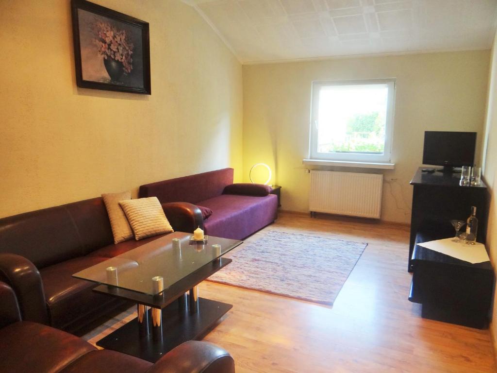 a living room with a couch and a table at Familijny Apartament z Garażem in Legnica