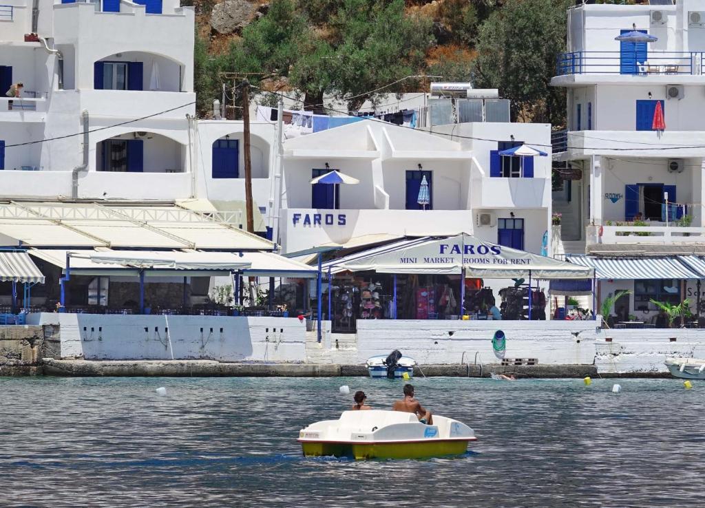 
a man and a woman on a boat in the water at Faros Rooms in Loutro
