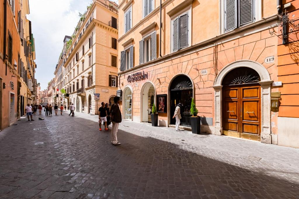 grupa ludzi idących po brukowanej ulicy w obiekcie Frattina High-end apt w Rzymie