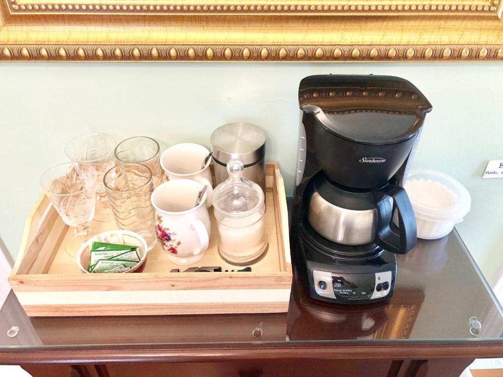 a coffee maker and cups on a table at Redwood Bed and Breakfast in Niagara Falls