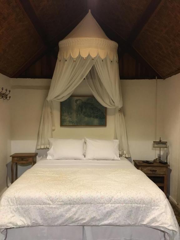 um quarto com uma grande cama branca e um dossel em Casa Caminho do Corcovado no Rio de Janeiro