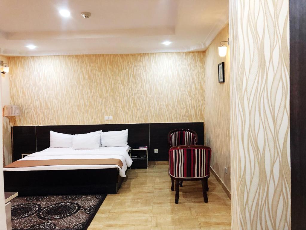 Habitación de hotel con cama y silla en Fawzy Hotel, en Ibadán