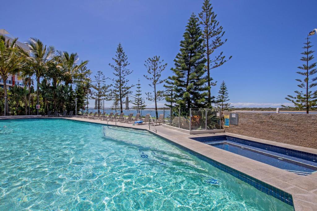 a swimming pool with blue water in a resort at Silvershore Apartments on the Broadwater in Gold Coast