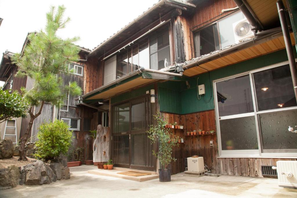a building with large windows and a green facade at Guest House tokonoma in Shimo-yuge