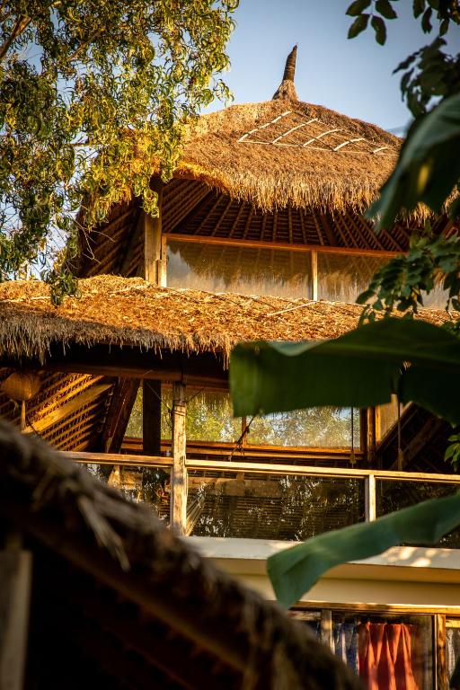 un edificio con tetto in paglia e tetto di paglia di Vertical House Bali a Uluwatu