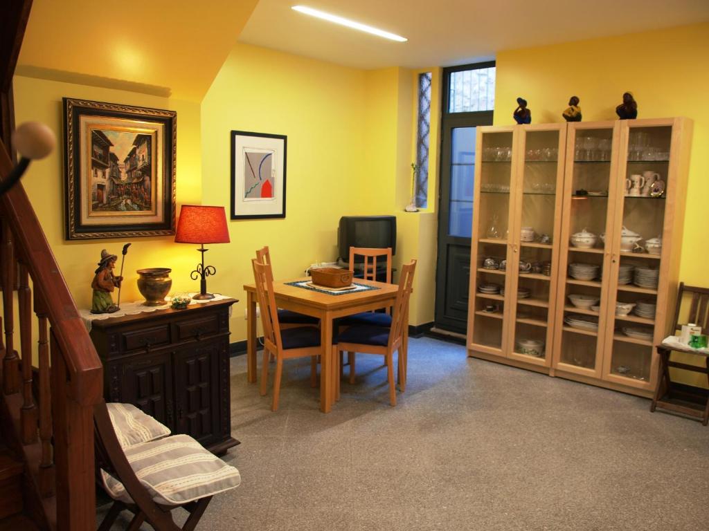 a dining room with a table and chairs and yellow walls at 107 Rosario, Guesthouse in Porto