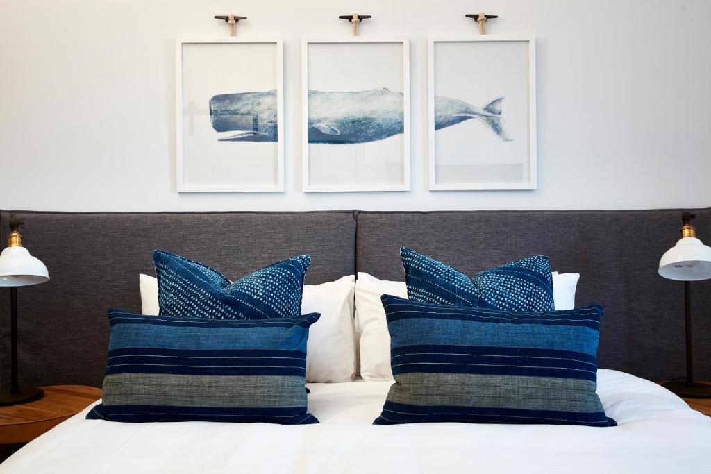 a bedroom with a bed with blue and white pillows at The Clovelly Hotel in Sydney