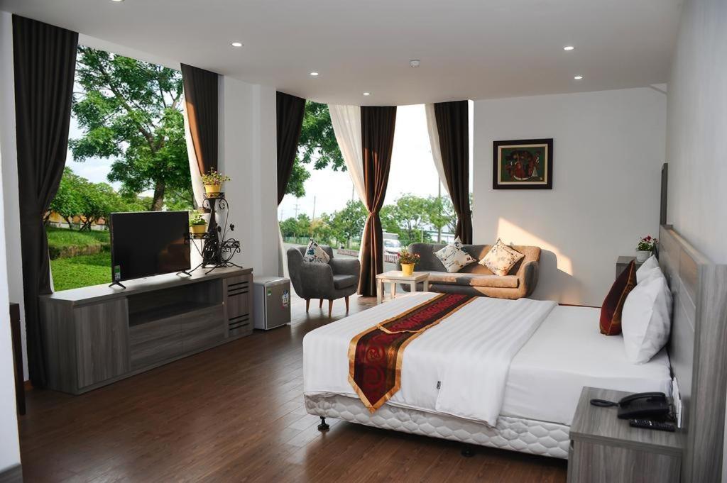 a bedroom with a bed and a tv and a window at Soo Hotel Bac Ninh in Bắc Ninh