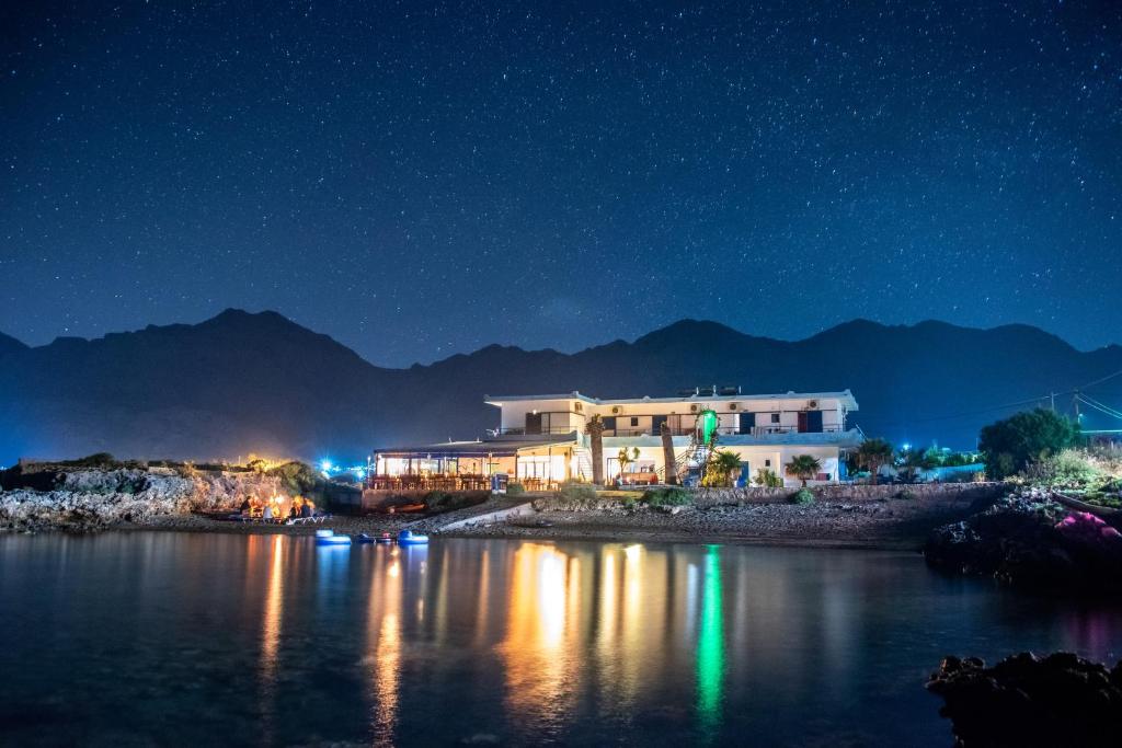 a building on the shore of a lake at night at Coral in Frangokastello