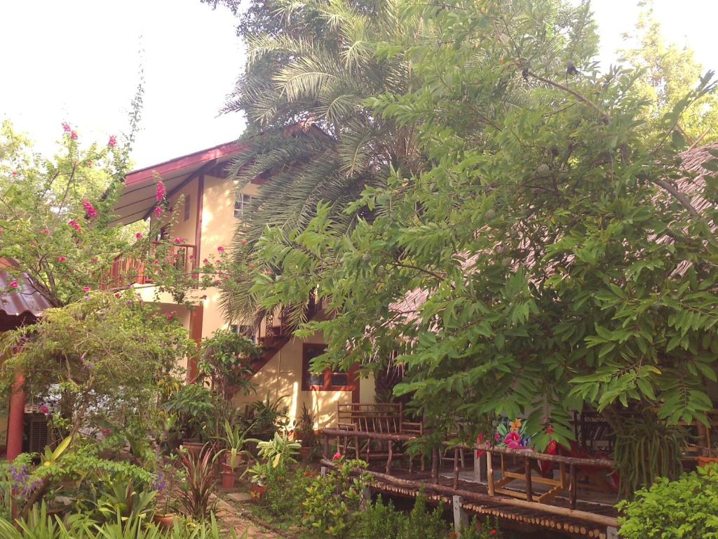 a house surrounded by trees and plants at Ban Sabai Sabai Guest House in Kanchanaburi City