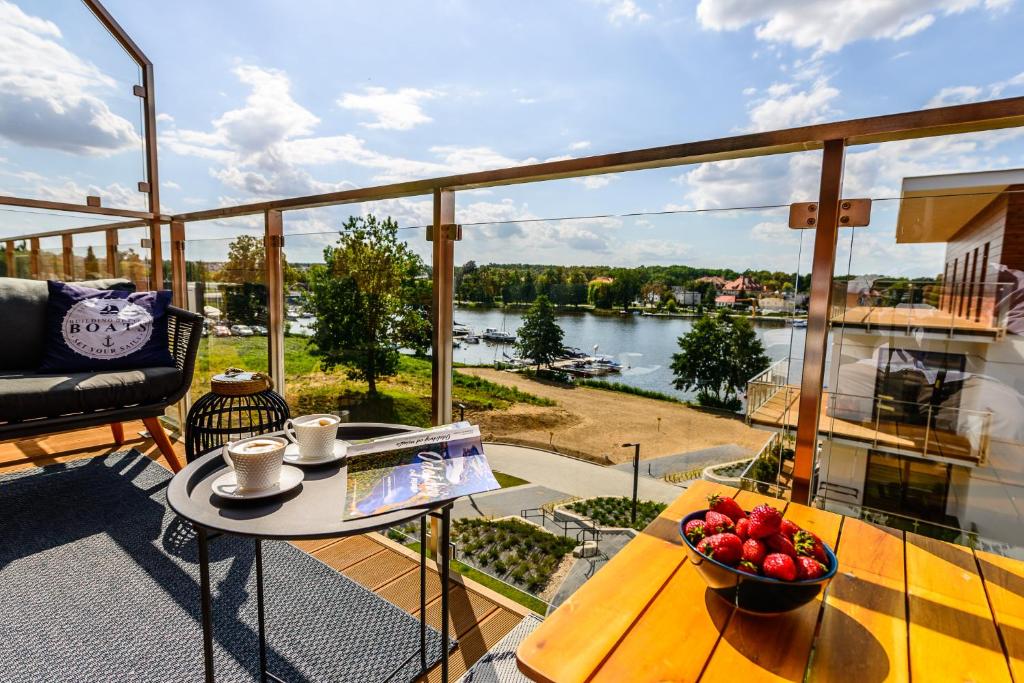 een balkon met een tafel en een fruitschaal bij Marina View Apartment z prywatnym parkingiem w hali garażowej in Iława