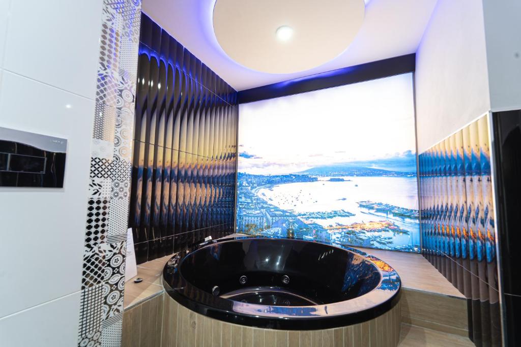 ein Badezimmer mit einer schwarzen Badewanne und einem großen Fenster in der Unterkunft Al Campanile H Napoli Centro, by ClaPa Group in Neapel
