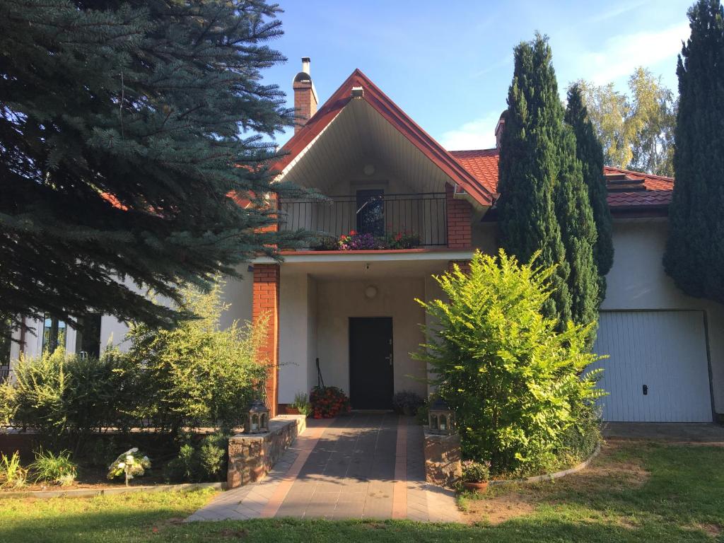 a house with a porch and a balcony at Willa Tini Sauna Basen in Gościno