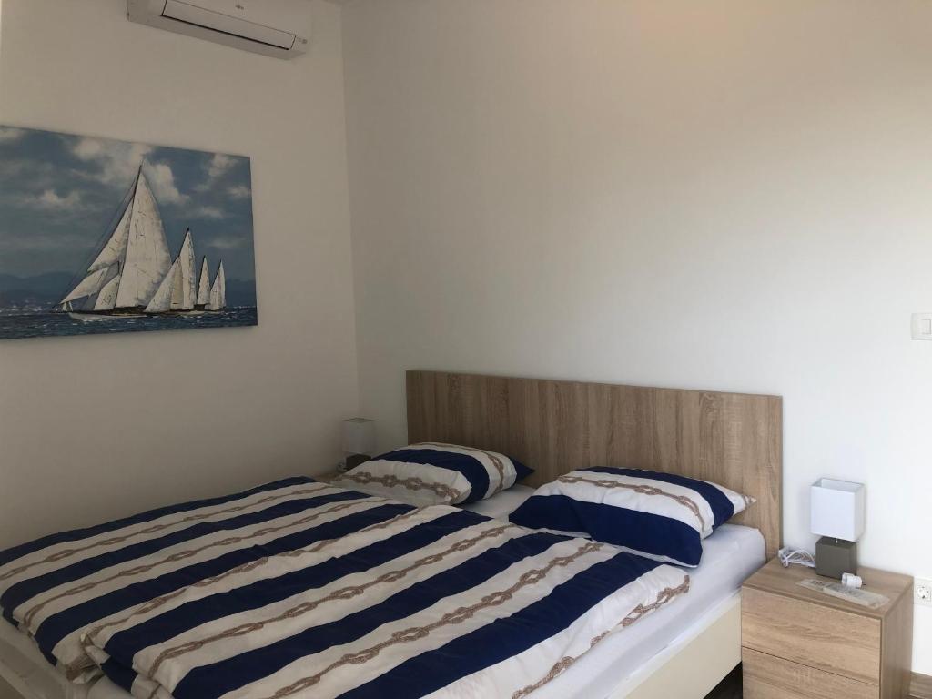 ein Schlafzimmer mit einem Bett mit einem Segelboot an der Wand in der Unterkunft Ideal Holiday Apartment 2 in Tribunj