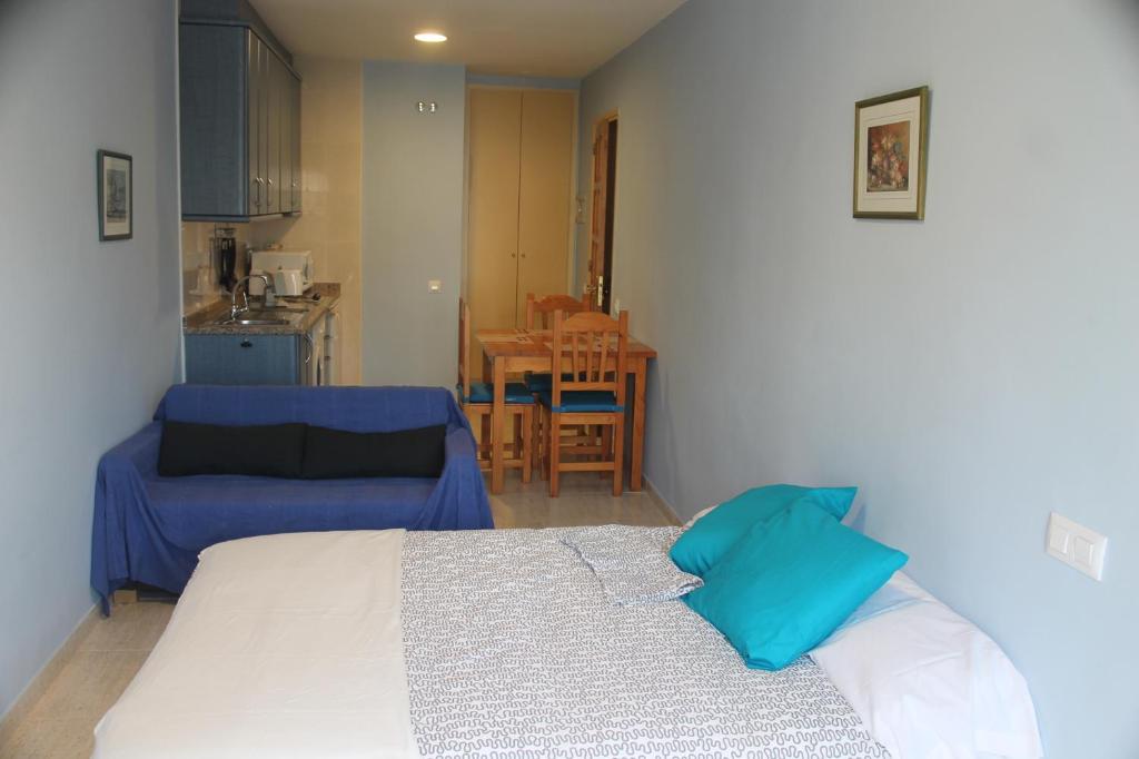 1 dormitorio con cama y sofá en Apartaments Can Claudi, en Tossa de Mar