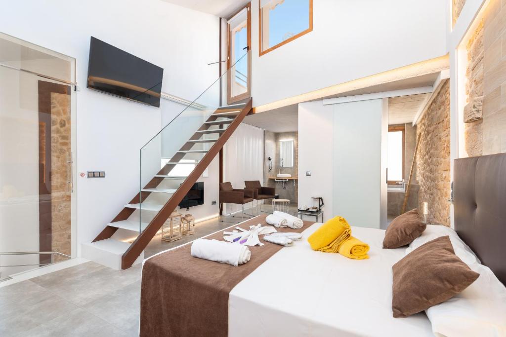 a bedroom with a large bed and a staircase at Hotel Can Simo in Alcudia
