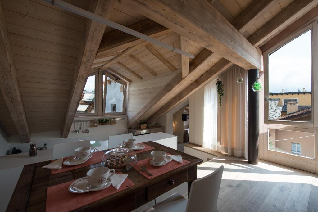 a dining room with a wooden table and some chairs at Il Riposo del Gladiatore in Aosta