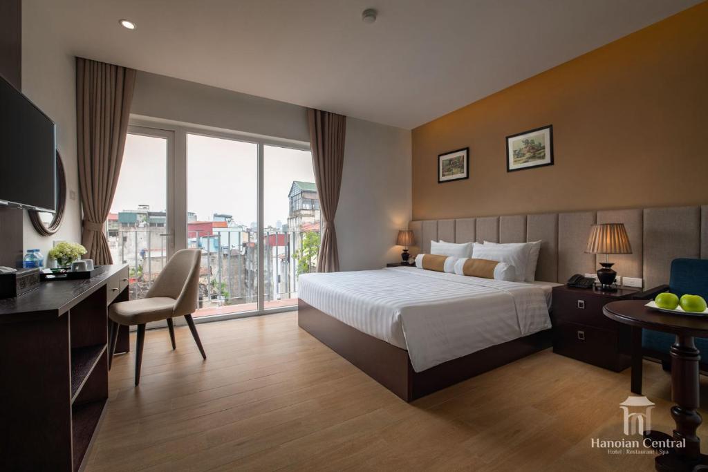 ein Hotelzimmer mit einem Bett und einem großen Fenster in der Unterkunft Hanoian Central Hotel & Spa in Hanoi