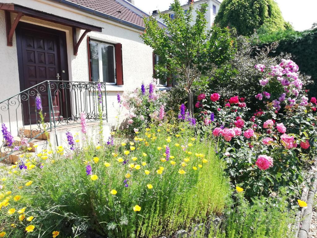 un jardin de fleurs devant une maison dans l'établissement Les Rosiers d'Y, à Nevers