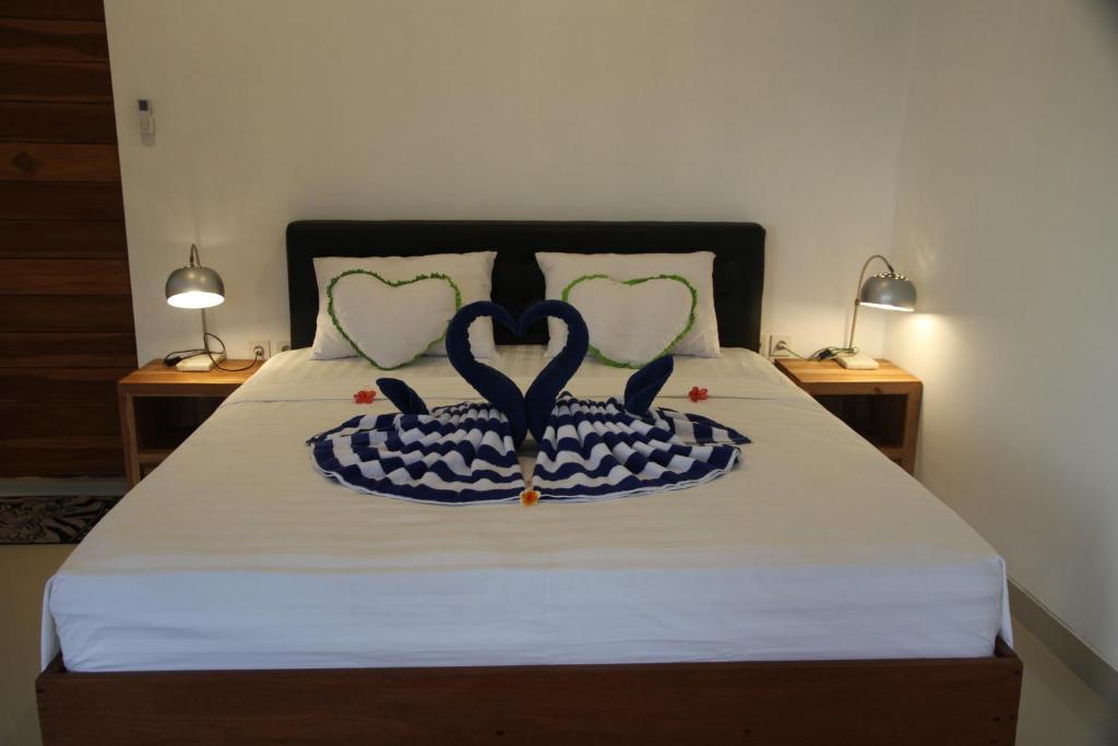 a bed with two pillows in the shape of hearts at Karma Amed Guesthouse in Amed