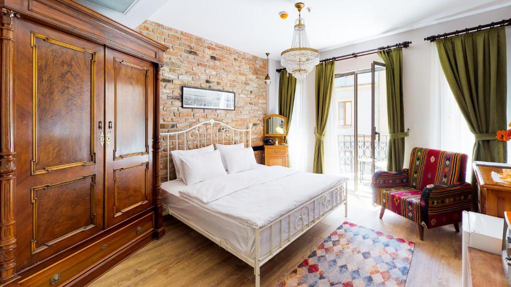 Hotel Des Arts Galata في إسطنبول: غرفة نوم بسرير وجدار من الطوب