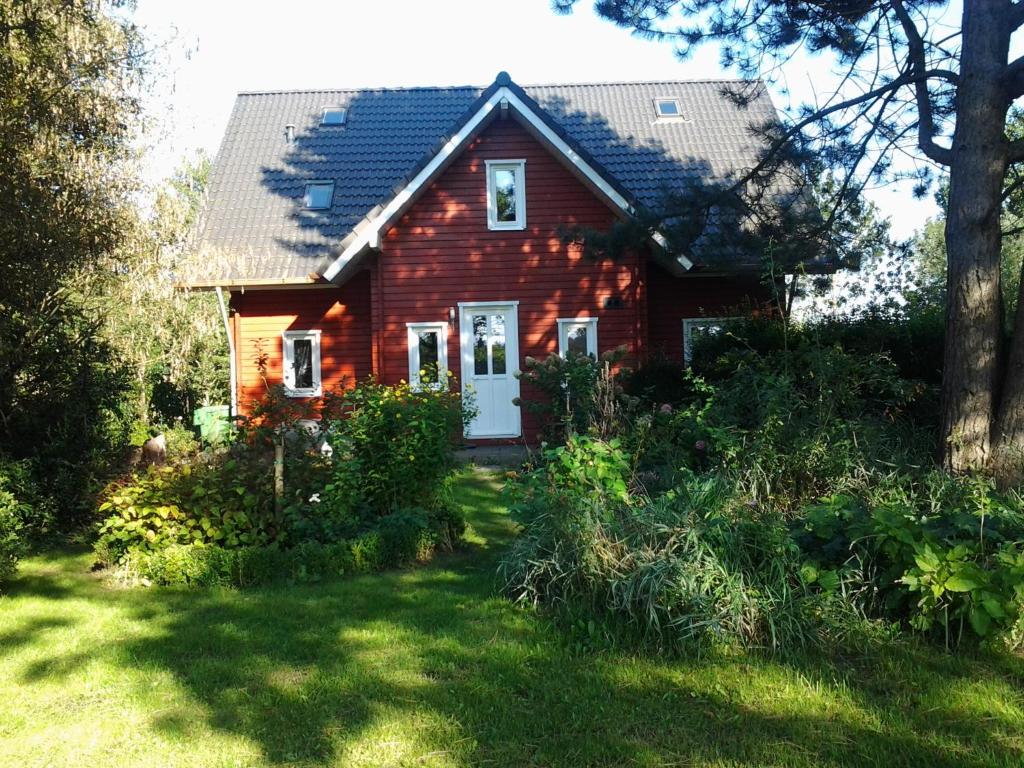 OostwoldにあるB&B Meerlandの庭白い扉付き赤い家