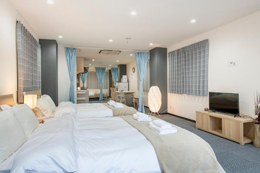 a bedroom with a large white bed and a television at Uhome Ueno Apartment 4 in Tokyo
